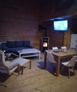uma sala de estar com um sofá, uma mesa e uma lareira em Felsenlandblick em Dahn