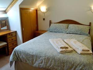 ソーンヒルにあるOld Tannery Cottageのベッドルーム1室(ベッド1台、タオル2枚付)