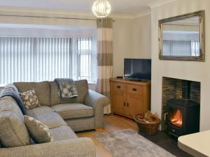 a living room with a couch and a fireplace at Hafod Y Bryn in Benllech