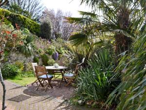 a table and chairs in a garden with plants at Beech Cottage in Whitwell