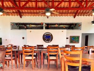 uma sala de jantar com uma mesa longa e cadeiras em Blue Banyan Inn em Quepos