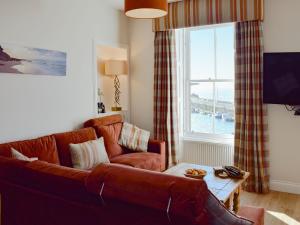 sala de estar con sofá y ventana en Harbourside Apartment, en Anstruther