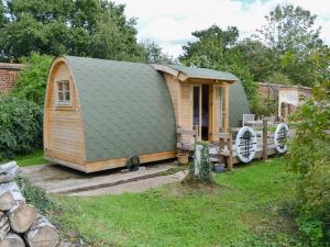 una casa pequeña con un techo verde en un patio en The Squirrels strelley Barn, en Woodham Mortimer