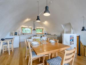 a dining room and kitchen with a wooden table and chairs at Jack Strawbale House - Uk7521 in Strontian