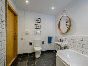 a bathroom with a toilet and a sink and a tub at Jack Strawbale House - Uk7521 in Strontian