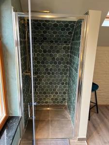 um chuveiro com uma porta de vidro num quarto em Cosy little house em Kraainem