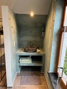een badkamer met een wastafel in de hoek bij Cosy little house in Kraainem