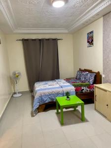 um quarto com uma cama e uma mesa verde em GHEST HOUSE BASS em Dakar