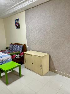 um quarto com uma cama, uma mesa verde e uma parede em GHEST HOUSE BASS em Dakar