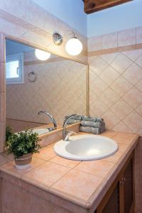 Un mostrador de baño con un lavabo y un espejo. en Kassiopi Central House, en Kassiopi 13 fotos más