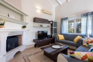 Una sala de estar con un sofá y una chimenea. en Kassiopi Central House, en Kassiopi