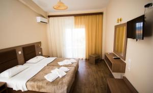 Habitación de hotel con 2 camas y TV de pantalla plana. en Hotel Maria en Possidi