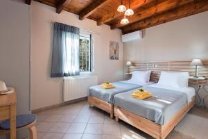 Un dormitorio con dos camas y una ventana. en Kassiopi Central House, en Kassiopi