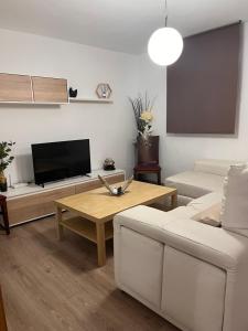 sala de estar con sofá y mesa en Apartamentos EL PELIGRO en Archidona