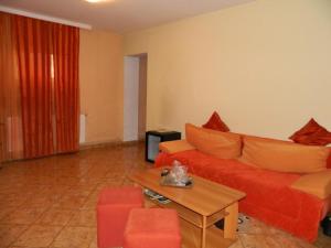 a living room with a red couch and a table at Complex Turistic Paralela'45 in Băicoi