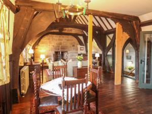 comedor con mesa, sillas y pared de piedra en Porter's Lodge, en Tamworth