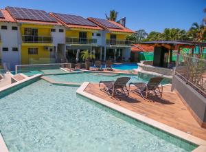 a swimming pool with two chairs and a house at Marruá Hotel in Bonito