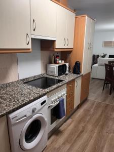 a kitchen with a washing machine and a microwave at Apartamentos EL PELIGRO in Archidona