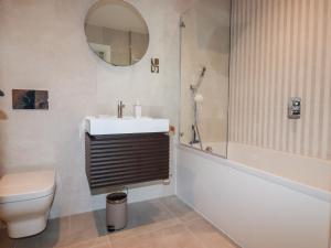 Un baño con lavabo, inodoro y espejo. en 33 Cliff Edge, en Newquay 41 fotos más