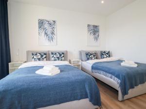 Dos camas en una habitación con azul y blanco. en 33 Cliff Edge, en Newquay