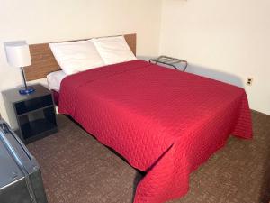 a bedroom with a bed with a red blanket at Cardinal Motel in North Wildwood