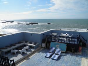 uma varanda com cadeiras e uma mesa e o oceano em La Maison des Artistes em Essaouira