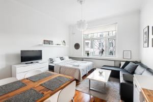 a white living room with a table and a couch at WeHost Heart of Helsinki Studio with Top Amenities in Helsinki