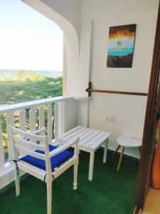 a white bench sitting on a balcony with a window at Sea la vie II in Kwale