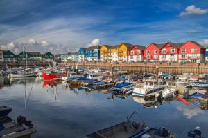 a group of boats in a marina with colorful houses at Number 15 Luxurious Two Bedroom Apartment in Exmouth
