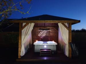 einen Pavillon mit einem Tisch und Stühlen in der Nacht in der Unterkunft Les Mini-Chaumières in Saint-Martin-Saint-Firmin