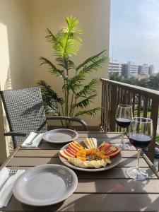 una mesa con dos platos de comida y dos copas de vino en SunDream1 home en Alicante