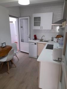 a kitchen with white appliances and a table and chairs at Apartamento El Nido in La Guardia