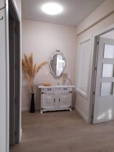 Baño blanco con espejo y lavabo en Apartamento El Nido, en La Guardia
