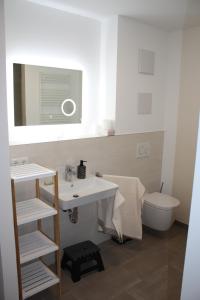 a bathroom with a sink and a toilet and a mirror at Traumwohnung Füssen 22 in Füssen +26 photos