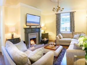 a living room with two couches and a fireplace at The Hind House in Cowlam