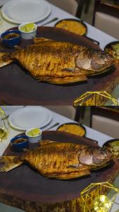 two fish on plates on a table with food at Marruá Hotel in Bonito