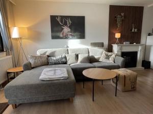 ein Wohnzimmer mit einem Sofa und einem Hirschgemälde in der Unterkunft Modern Holiday Home in Lechbruck with Terrace in Bichel