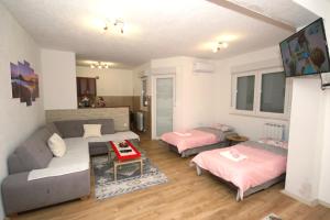 a living room with a couch and two beds at Apartman Mladen in Trebinje