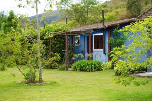 a blue house in the middle of a yard at Campos da Bocaina in São José do Barreiro
