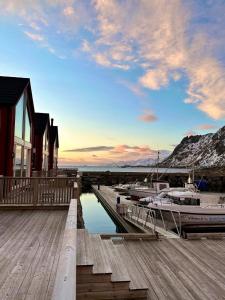 a boat is docked at a dock with a house at Lofoten seaview in Ballstad