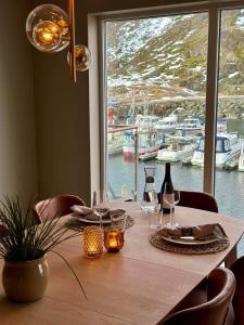 a table with wine glasses and a view of a marina at Lofoten seaview in Ballstad