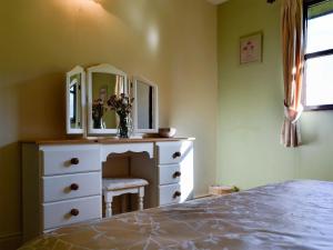 a bedroom with a white dresser and a mirror at Magpie - Uk6546 in Llanfihangel-Bryn-Pabuan
