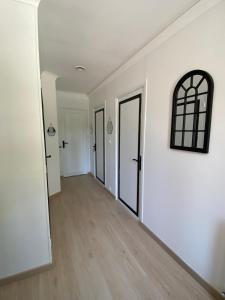 an empty hallway with white walls and wooden floors at Chambre d'hôtes Zephyr Libeccio Le Moulin de Prédelles in Reillanne