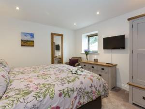 a bedroom with a bed and a desk and a tv at The Barn At Toft Hill Hall in High Etherley