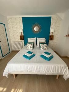 a bedroom with a large bed with a blue wall at Chambre d'hôtes Zephyr Libeccio Le Moulin de Prédelles in Reillanne