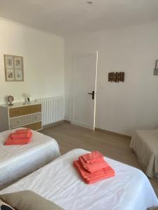 um quarto com duas camas com toalhas vermelhas em Chambre d'hôtes Zephyr Libeccio Le Moulin de Prédelles em Reillanne