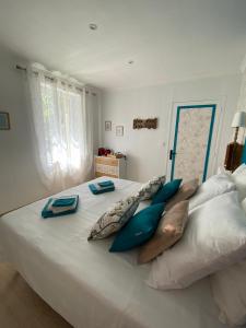 uma grande cama branca com almofadas em cima em Chambre d'hôtes Zephyr Libeccio Le Moulin de Prédelles em Reillanne