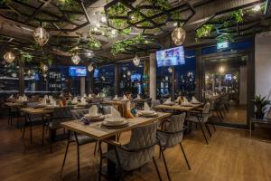 a dining room with tables and chairs and chandeliers at Design Hotel Winterrot in Karlsruhe