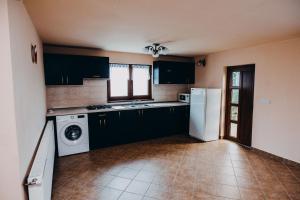 a kitchen with black cabinets and a white refrigerator at Casa Roland in Gheorgheni