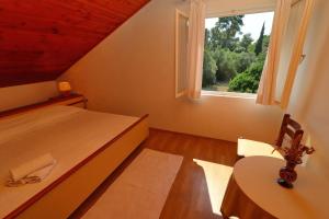 een slaapkamer met een bed, een raam en een tafel bij Apartment Star Day in Blato
